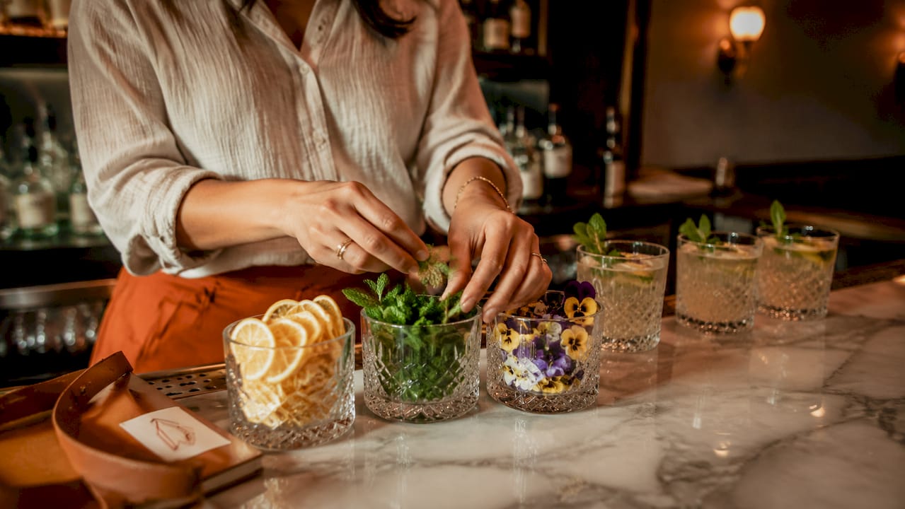 Close-up van een bartender die zorgvuldig cocktailgarneringen voorbereidt