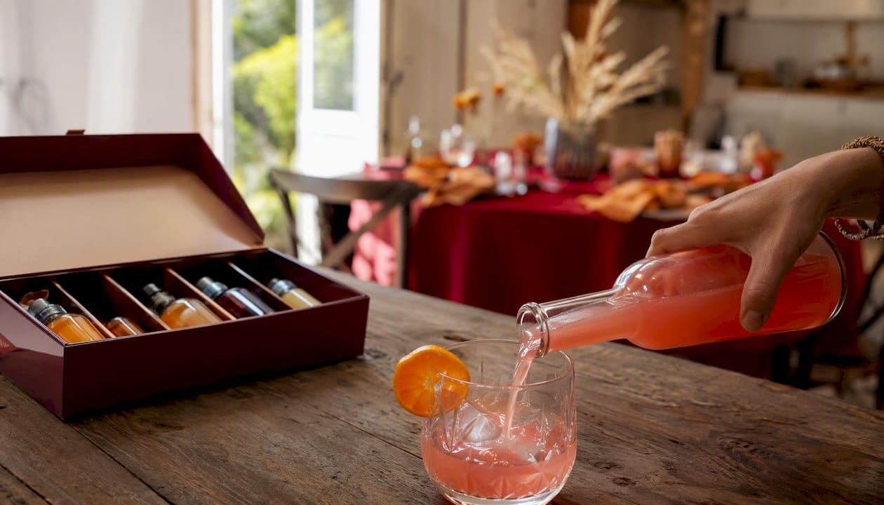 Een cocktailbox en een vers ingeschonken drankje op het aanrecht in de keuken.