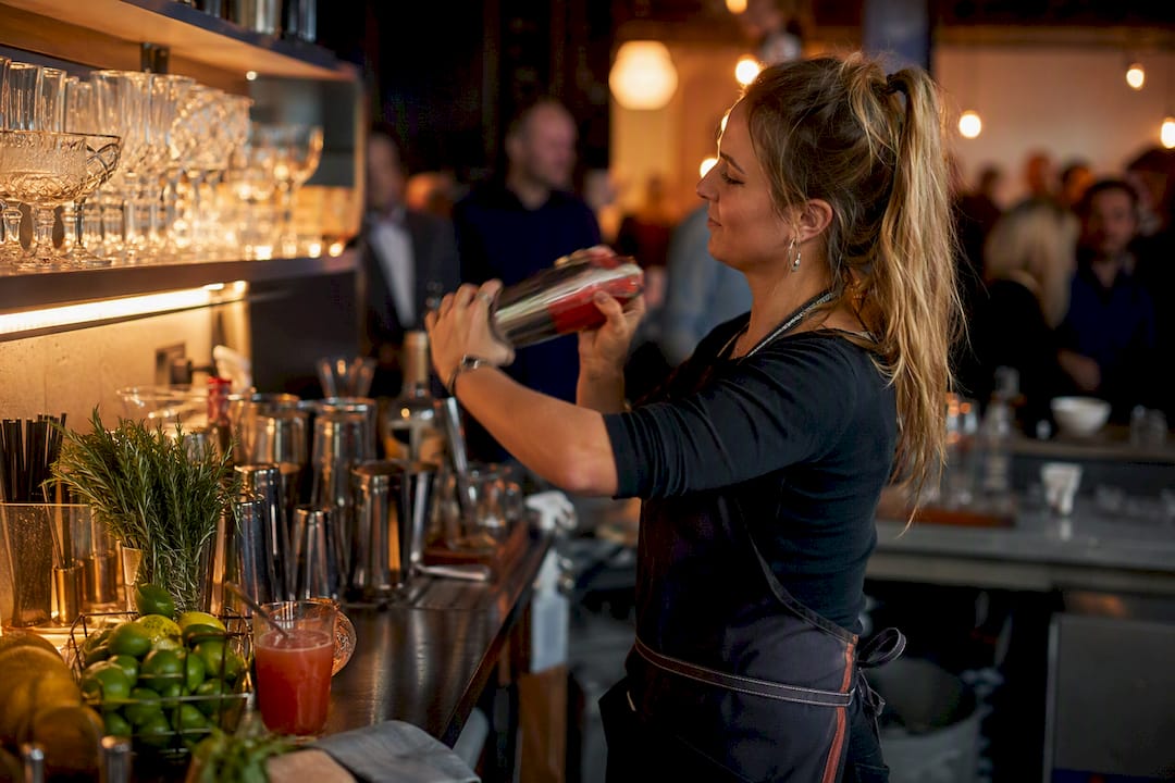 Barman die cocktail schudt tijdens bedrijfsfeest