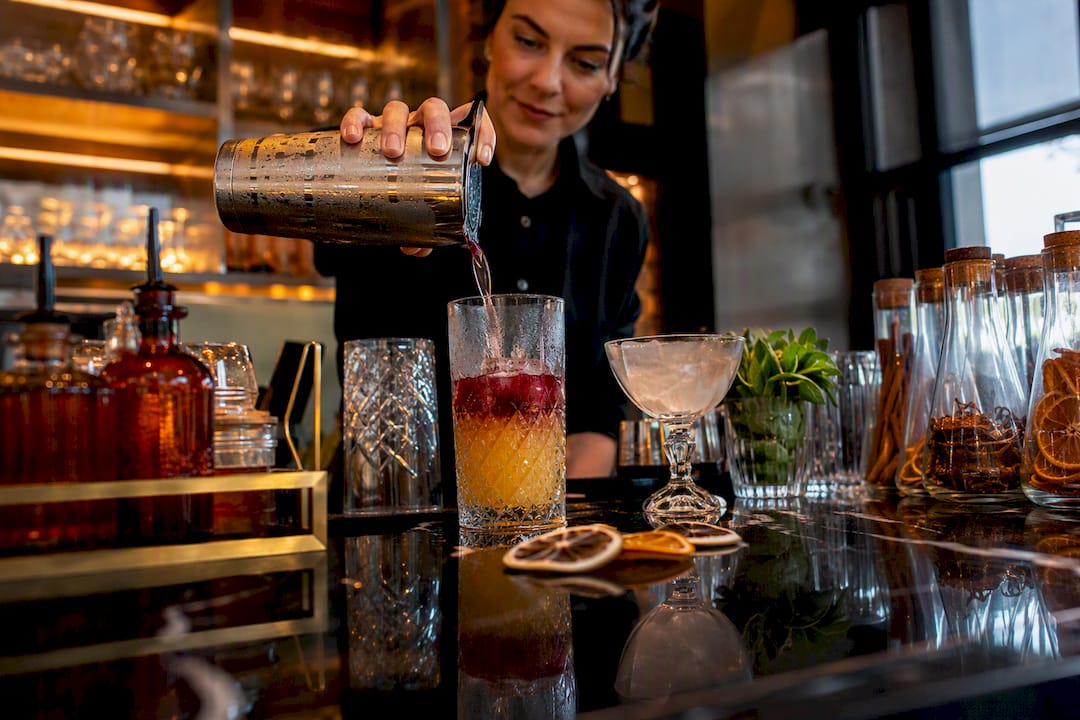Barman schenkt cocktail in een Nederlands café