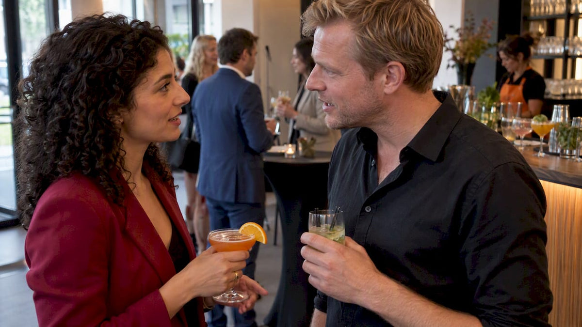 Twee gasten praten terwijl ze cocktails drinken tijdens de netwerkborrel