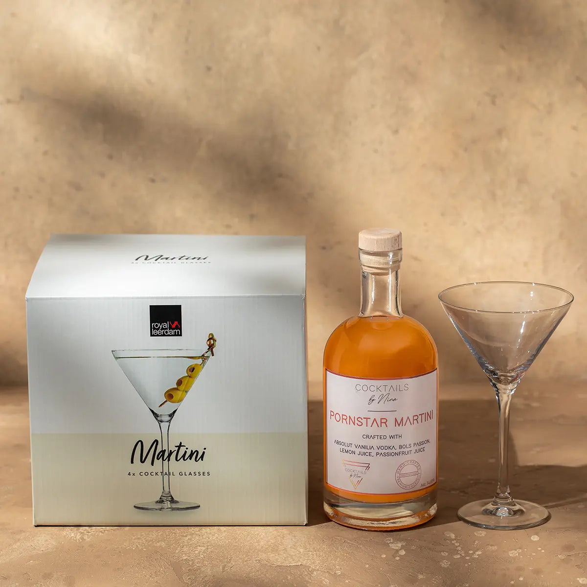 Martini glasses (26cl) displayed next to a bottle of Pornstar Martini and a gift box on a neutral background.-Cocktails by Nina