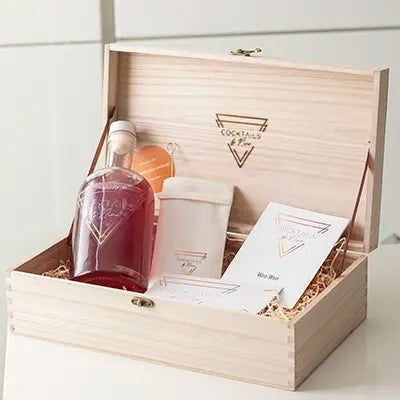 Wijnkistje waarin de cocktailfles op een bedje van stro ligt, inclusief bamboo rietjes.